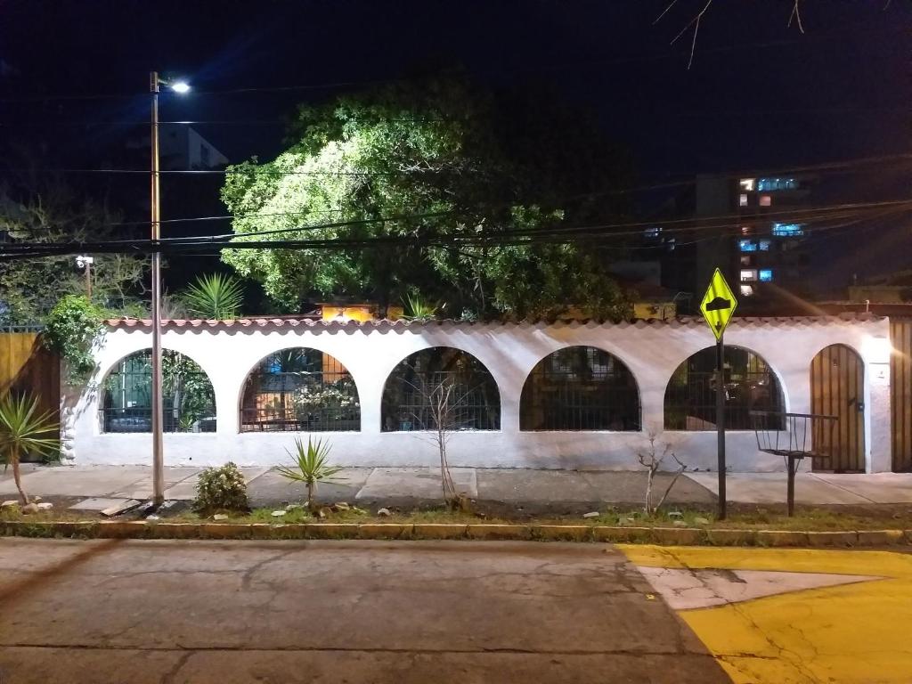 サンティアゴにあるHostal La Casa del Puenteの夜間のアーチ型の窓がある白い建物