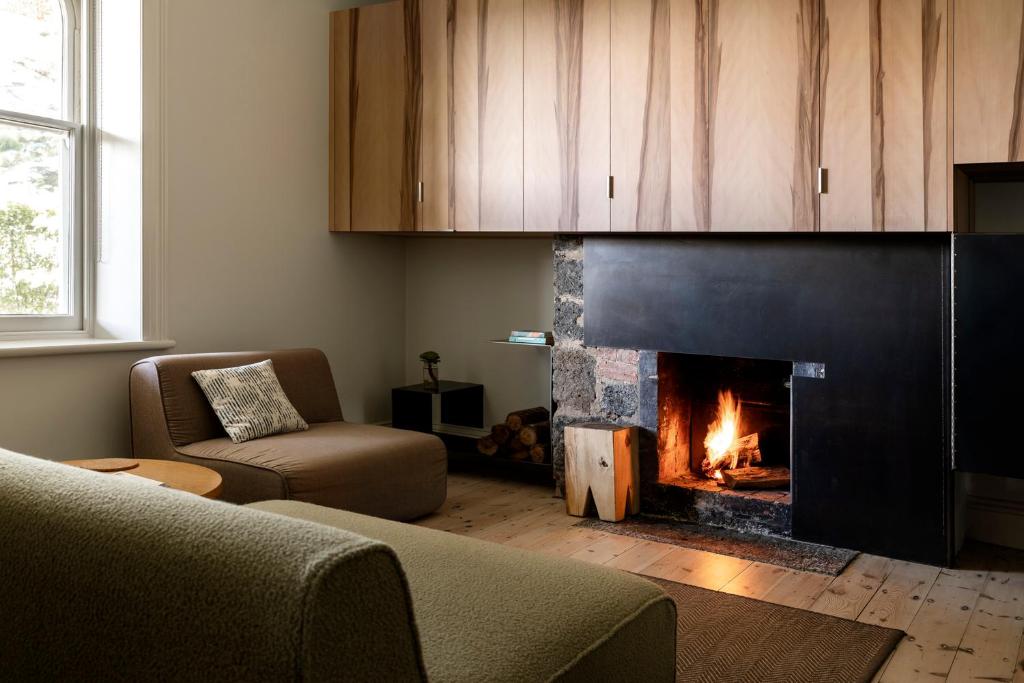a living room with a fireplace and a couch at Drift House in Port Fairy