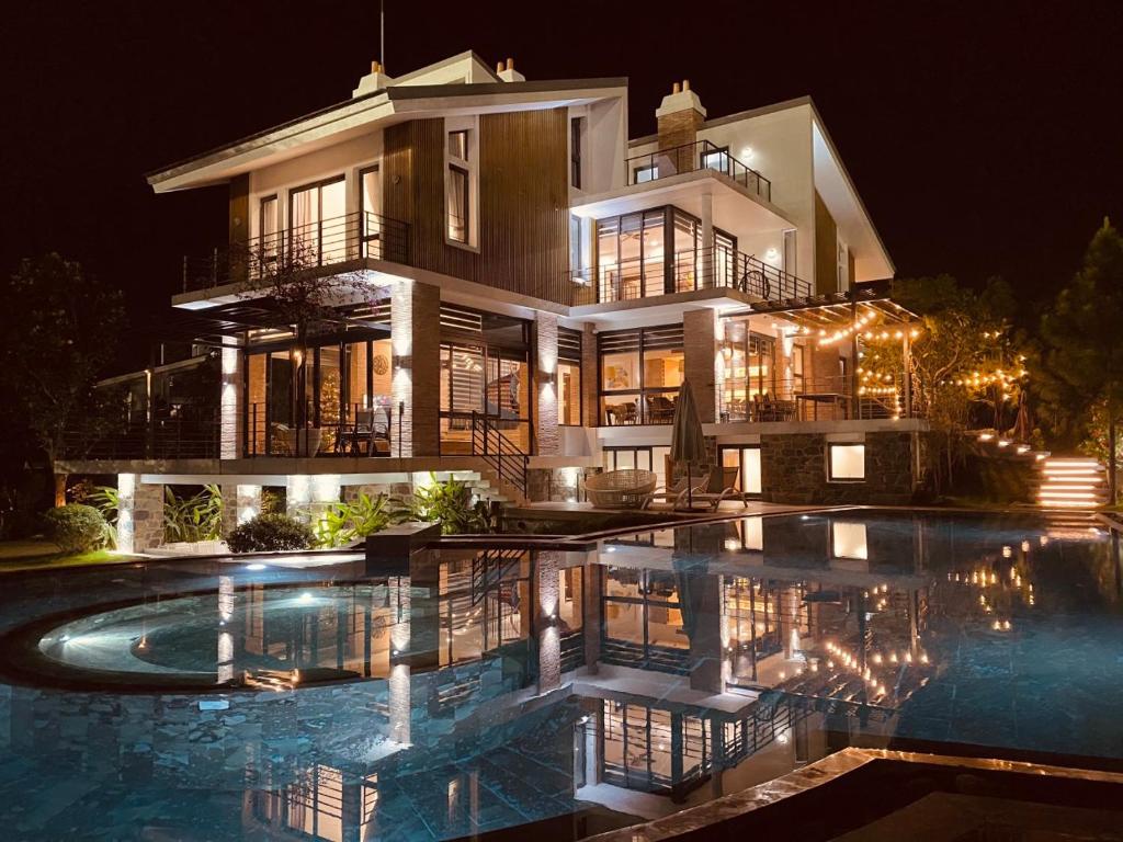 a large house with a swimming pool in front of it at Nam Casa Sân Golf Tam Đảo Venuestay in Tam Ðảo