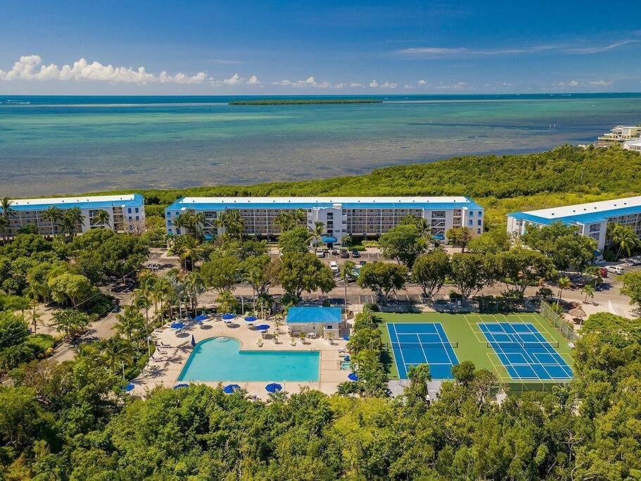 an aerial view of the resort with tennis courts and the ocean at Welcome to the Pelican Lodge ! in Tavernier