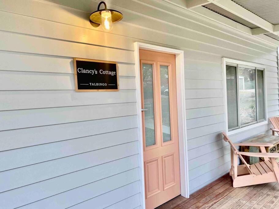 a front door of a house with a sign on it at Clancy's Cottage -Talbingo in Talbingo