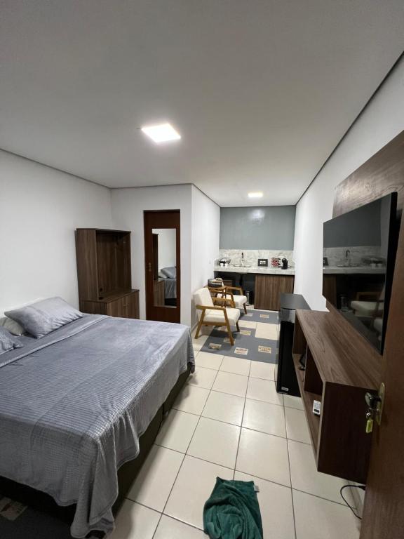 - une chambre avec un lit et un salon dans l'établissement Studio equipado centro, à São Lourenço da Serra