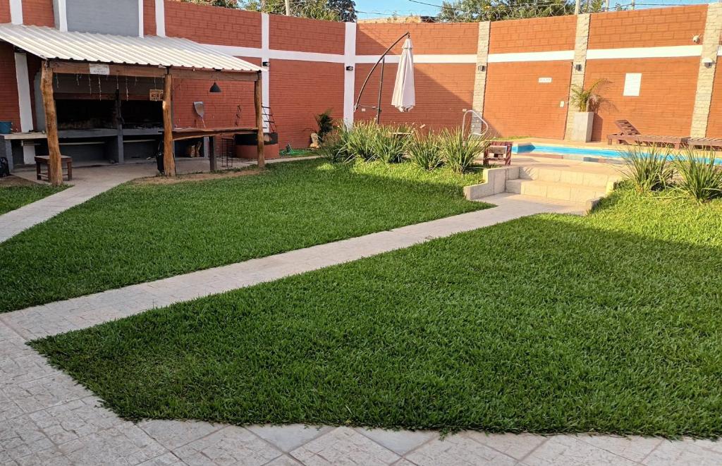 a grass yard with a pool and a building at Casa Quinta Los Amigos in Corrientes