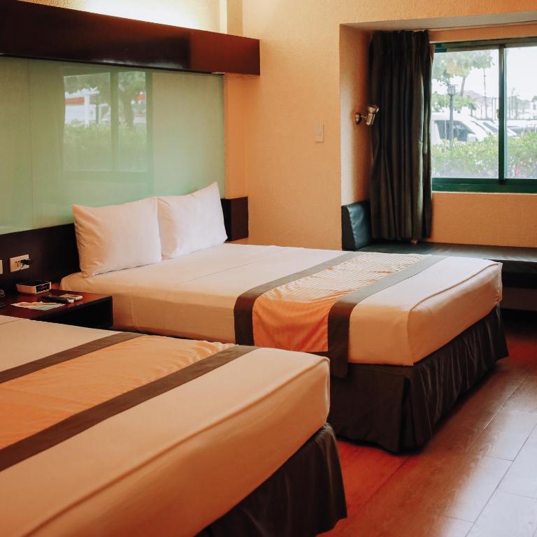 Postel nebo postele na pokoji v ubytování Microtel by Wyndham Cabanatuan