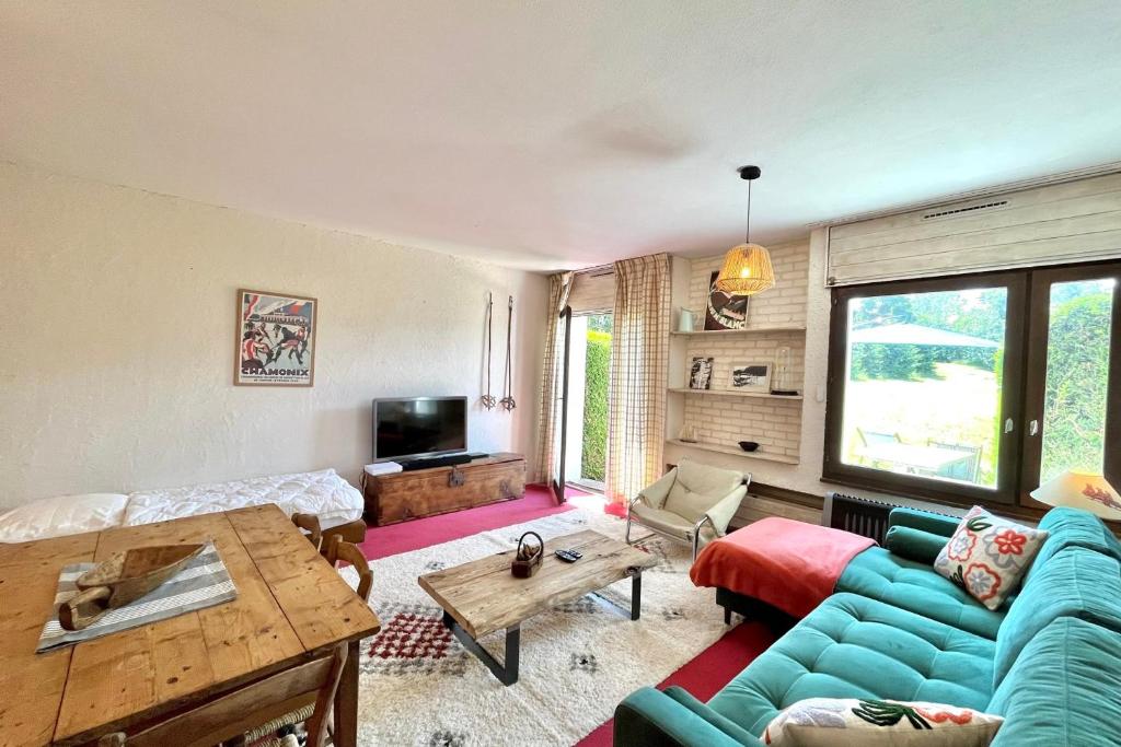 ein Wohnzimmer mit einem blauen Sofa und einem Tisch in der Unterkunft Nid d'Arbois in Megève