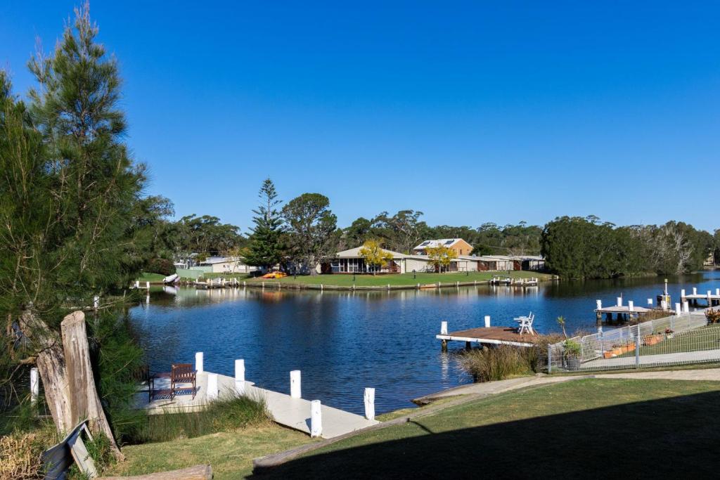 a view of a lake with a dock and houses at Holiday on the Water in Sussex Inlet