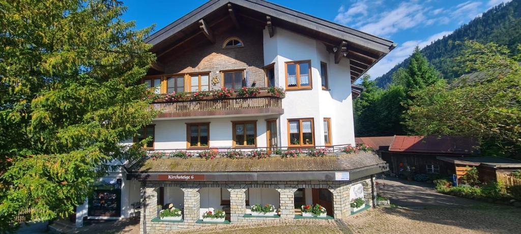 ein Haus mit einem Balkon mit Blumen darauf in der Unterkunft Ferienwohnung mit Sauna am Alpsee in Bühl am Alpsee