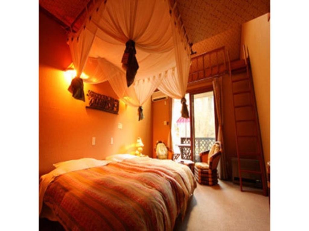 a bedroom with a bed with a canopy at Estivant Club - Vacation STAY 95670v in Tsumagoi