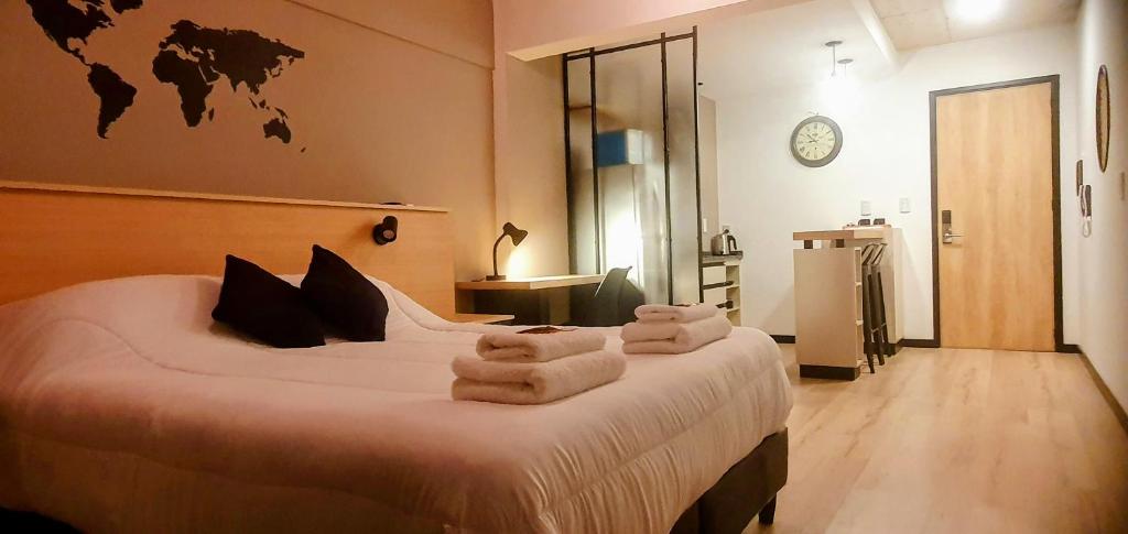a bedroom with a large bed with towels on it at Alsina Suite!! Hermoso y moderno apart en Salta!! in Salta