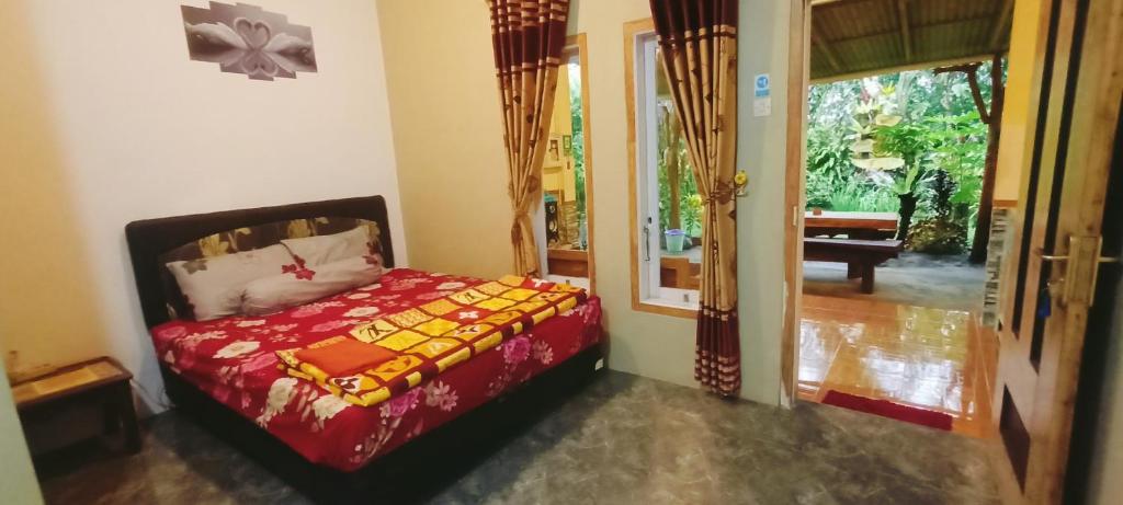 ein Schlafzimmer mit einem Bett in einem Zimmer mit einem Eingang in der Unterkunft FAREL HOMESTAY KAWAHIJEN in Banyuwangi