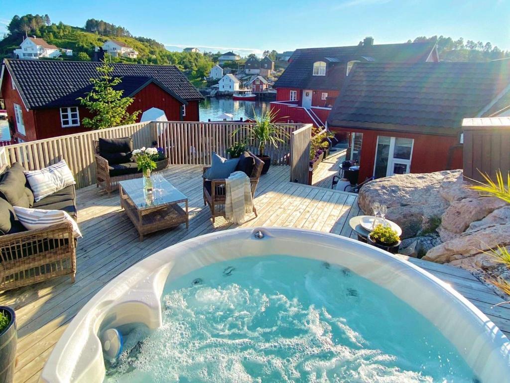 una gran bañera de hidromasaje en una terraza con patio en Holiday home averøy III en Averoy