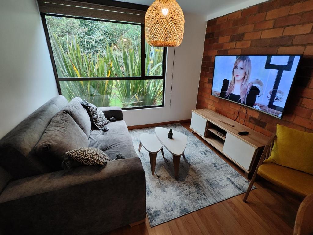 a living room with a couch and a flat screen tv at Awesome view and functional in the mountain ! in Bogotá