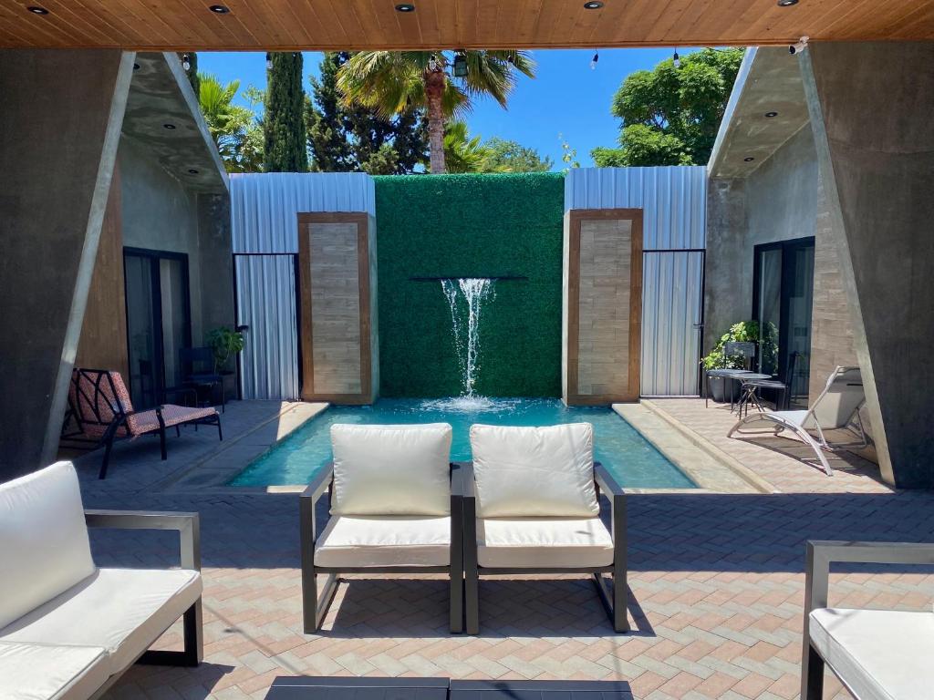 einen Pool mit einem Brunnen mit zwei Stühlen und einem Tisch in der Unterkunft Antia Valle de Guadalupe in Valle de Guadalupe