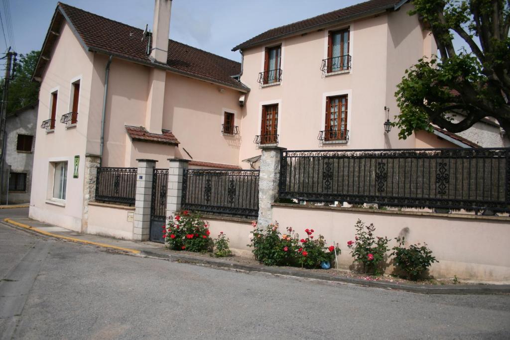 a white house with flowers on the side of a street at Le Pingouin in Bennecourt