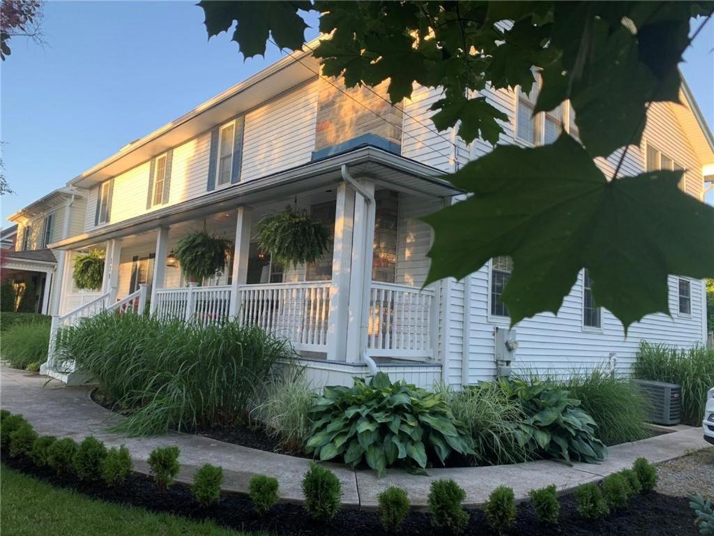 a white house with a porch and plants at Centre Gate House Licence# 117-2023 in Niagara-on-the-Lake