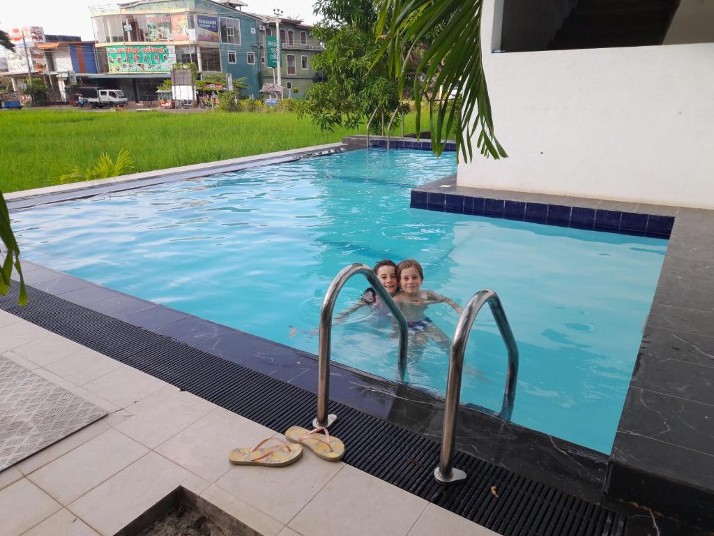 Eine Frau in einem Pool mit Sandalen. in der Unterkunft Traveller's Home Hotel in Tissamaharama