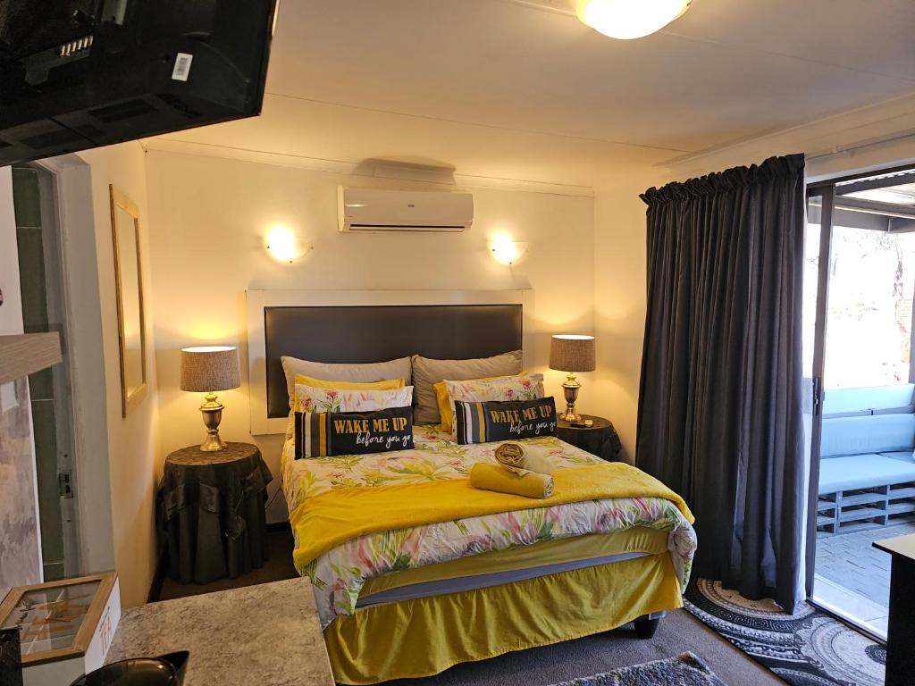 um quarto com uma grande cama amarela e 2 candeeiros em The Haven: Make our Home your Home em Estcourt