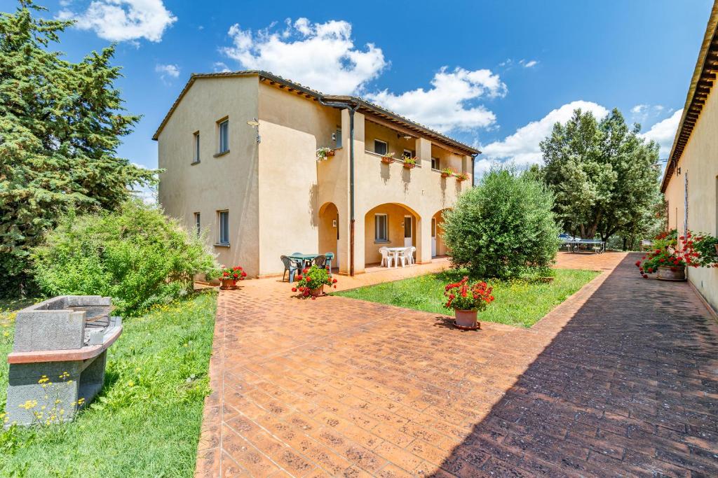 una vista exterior de una casa con entrada de ladrillo en Family Apartments With Pool Near Volterra - Happy Rentals, en Pomarance