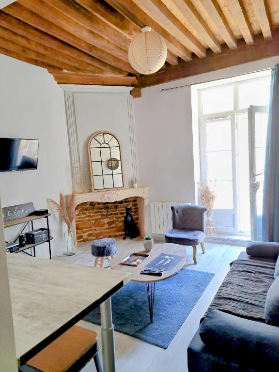 a living room with a couch and a table at La Maison du Bonheur - Logement entier de 39 m2 in Bourg-en-Bresse