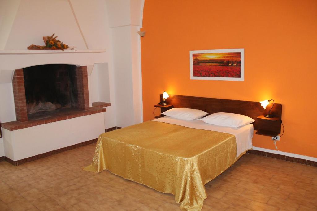 1 dormitorio con 1 cama y chimenea en B&B Masseria Donna Carlotta, en Serrano