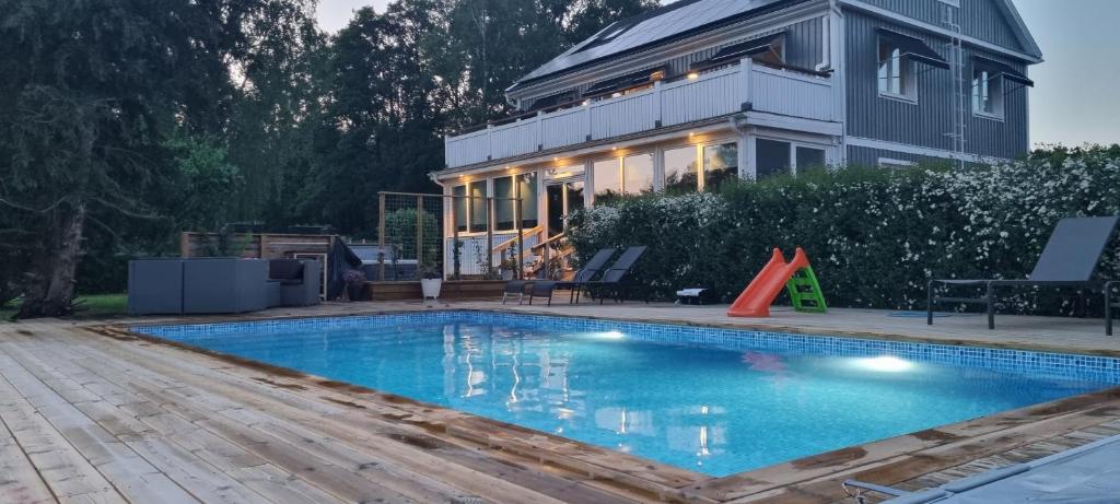 a house with a swimming pool in front of a house at Villa Elme in Växjö