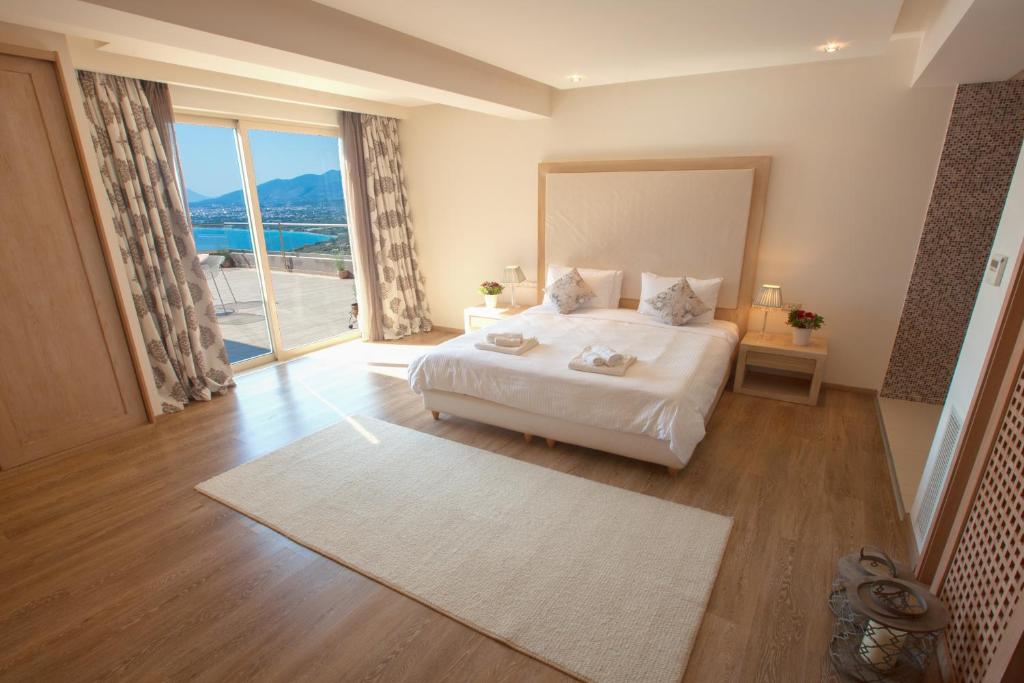 ein Schlafzimmer mit einem großen Bett und einem großen Fenster in der Unterkunft Belvedere Hotel in Kalamata