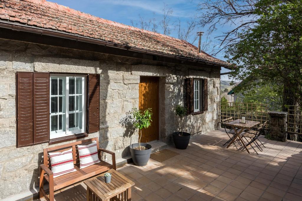 una casa in pietra con patio e tavolo di La Casita de Piedra a Cercedilla