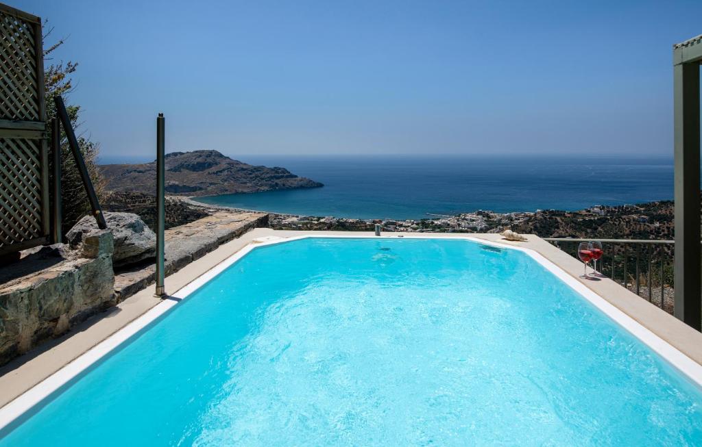 a swimming pool with a view of the ocean at Stefanos Village Hotel in Plakias