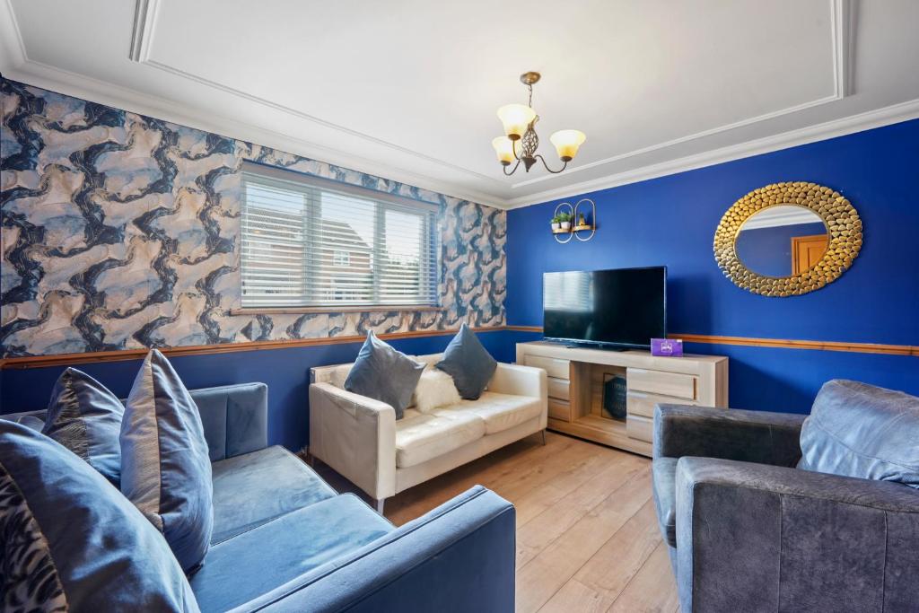 a blue living room with a couch and a tv at Ashford Home - Spacious house close to Ashford International and free drive parking and hot tub in Ashford
