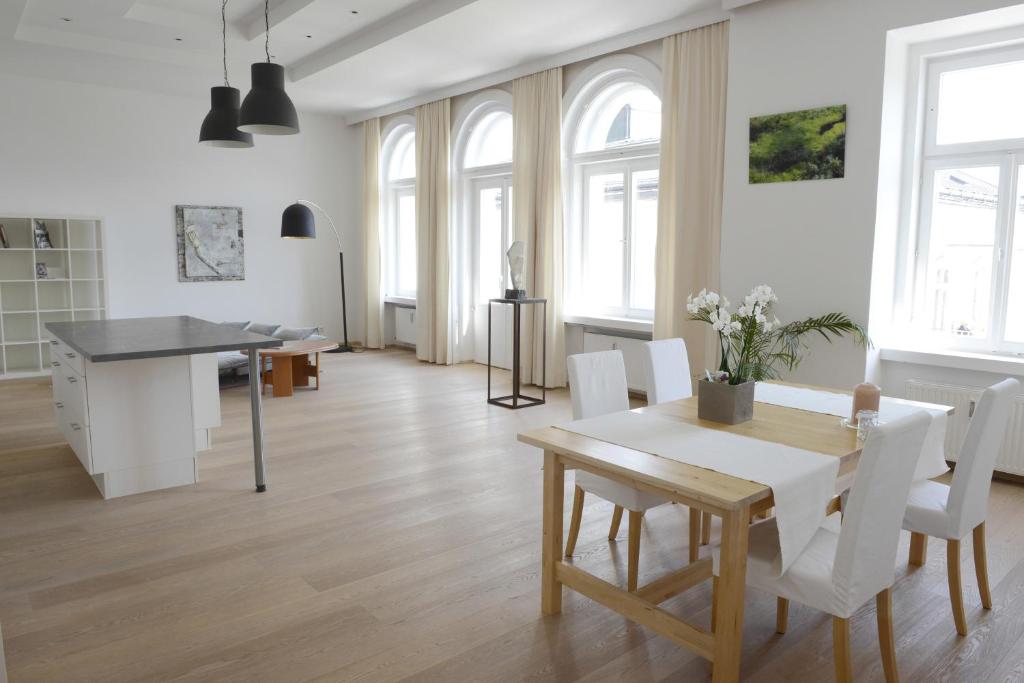 ein Wohnzimmer mit einem Tisch und weißen Stühlen in der Unterkunft Apartment am Traunsee in Gmunden