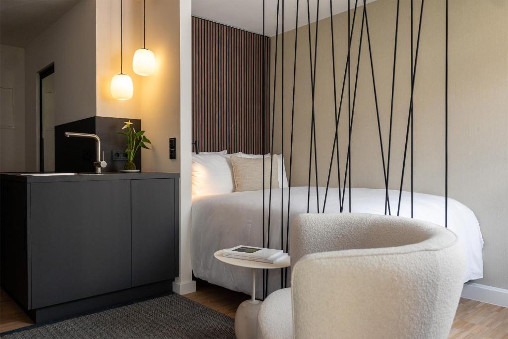 a bedroom with a bed with a chair and a desk at HApato in Munich