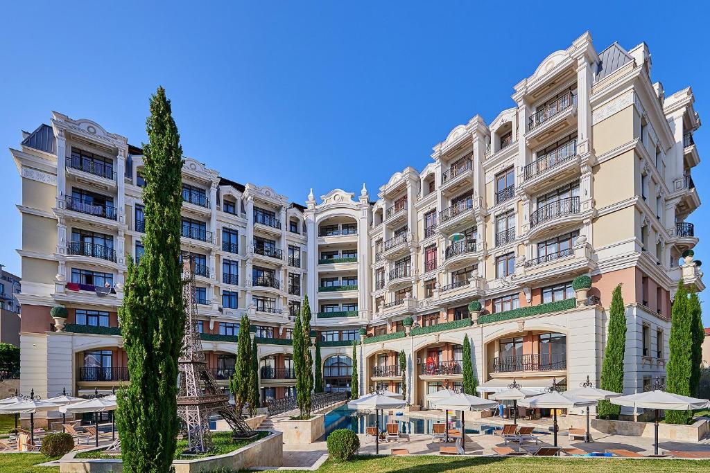 a large building with umbrellas in front of it at Florance Paris Luxury Apartments in Sveti Vlas