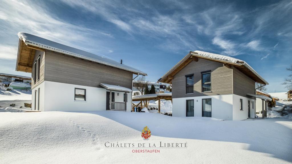 a house in the snow next to a building at Châlets de la Liberté B in Oberstaufen