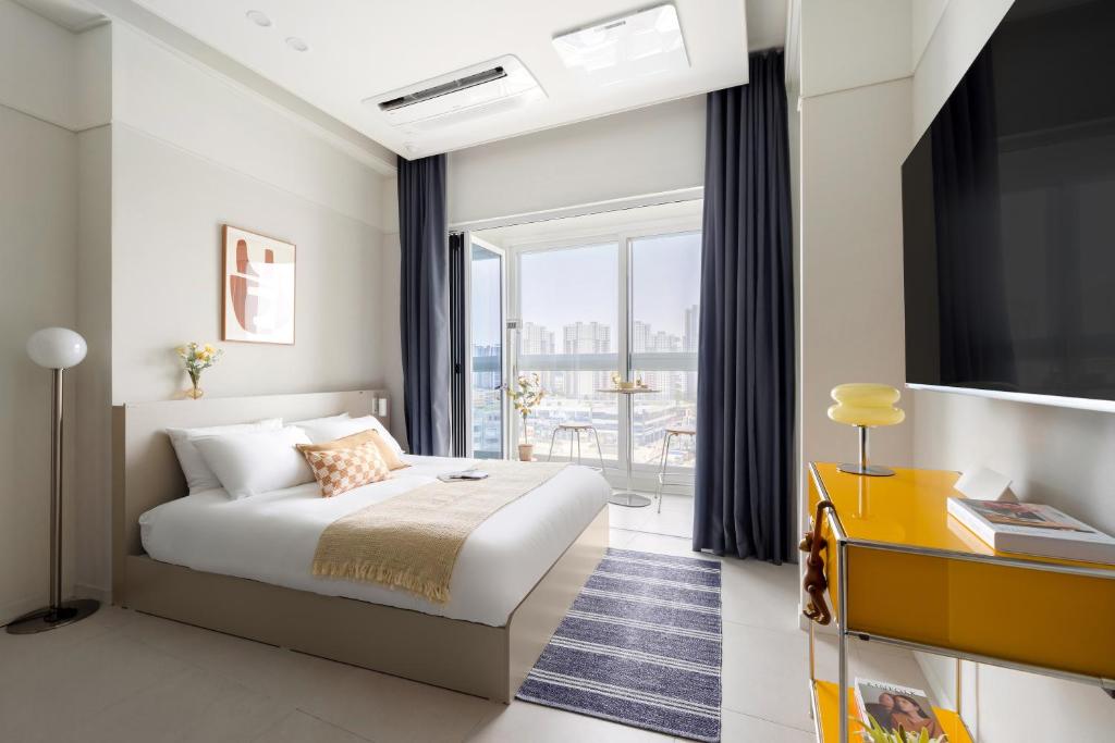 ein Schlafzimmer mit einem Bett und einem großen Fenster in der Unterkunft Le collective Siheung Wavepark in Siheung