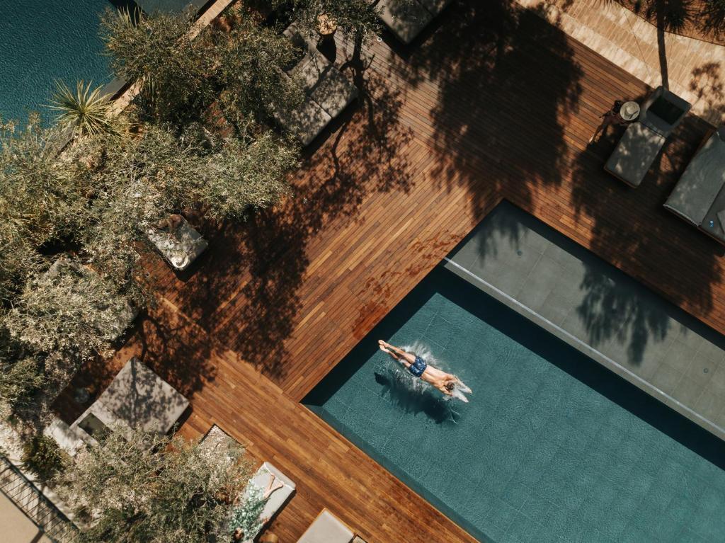 an overhead view of a person swimming in a swimming pool at Maslina Resort in Stari Grad