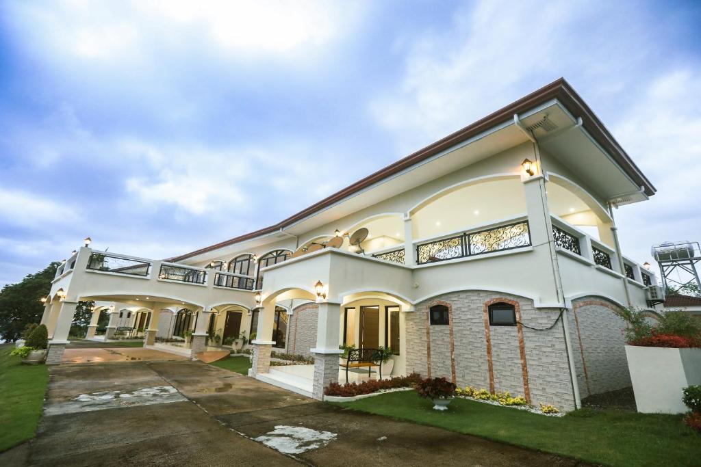 a large white house with a driveway at The Suites @ Bellavista in Isabel