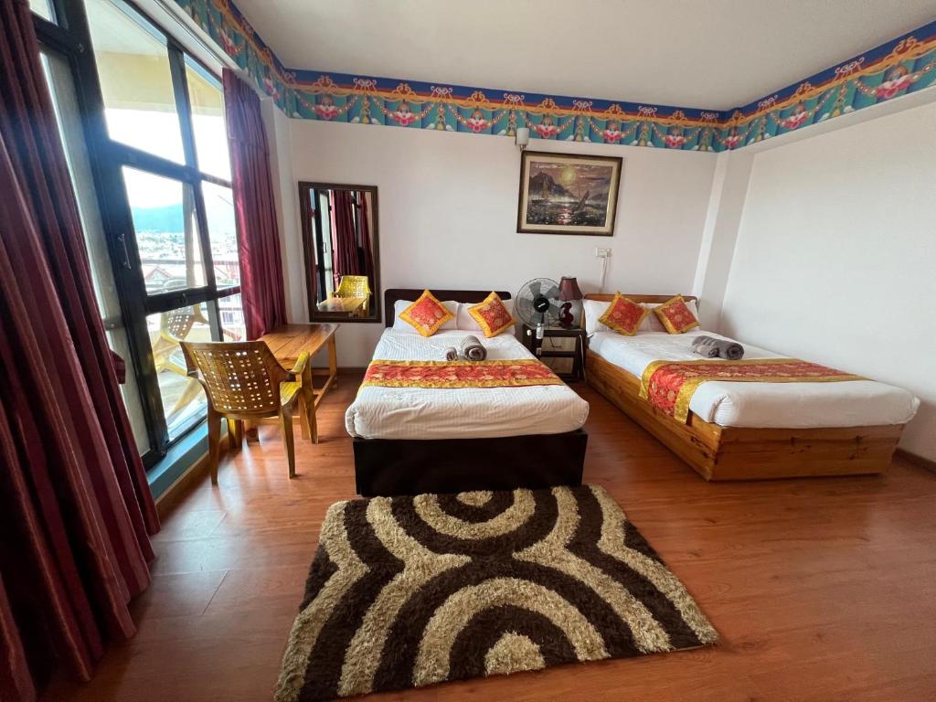 1 dormitorio con 2 camas, mesa y sillas en The Boudha Inn, en Katmandú