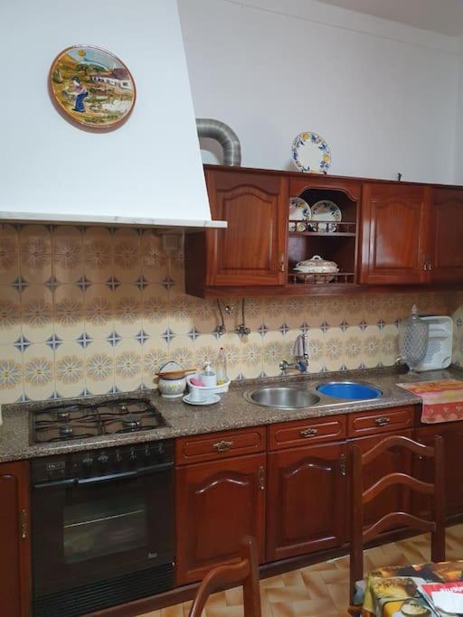 a kitchen with a sink and a stove top oven at Casa T1 em Alverca. in Arsena