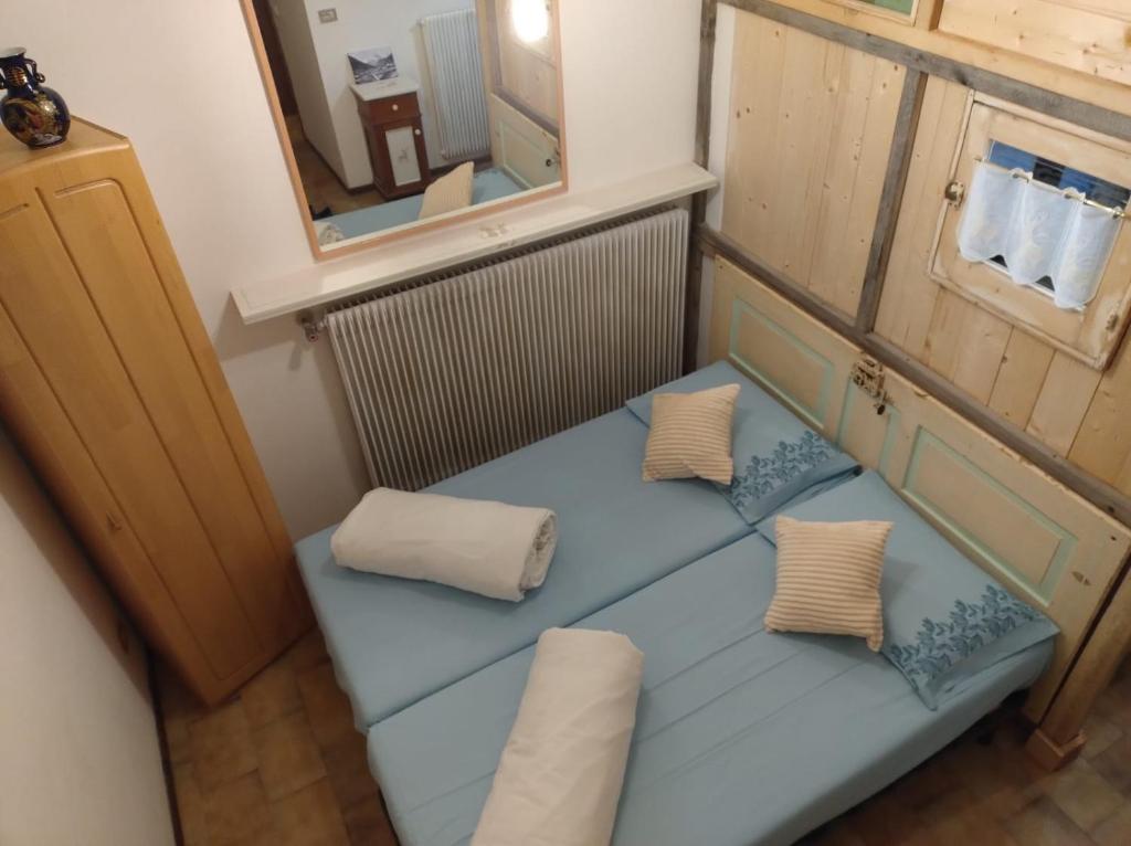 um pequeno quarto com um banco azul e um espelho em Ladinische Jagerhof - Solaria CIPAT: 022113-AT-013003 em Campestrin