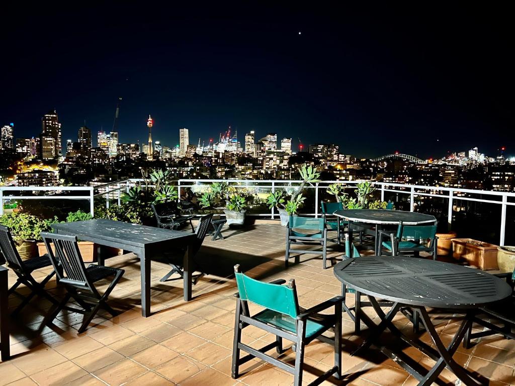a deck with tables and chairs and a view of a city at Studio in Darling Point in Sydney