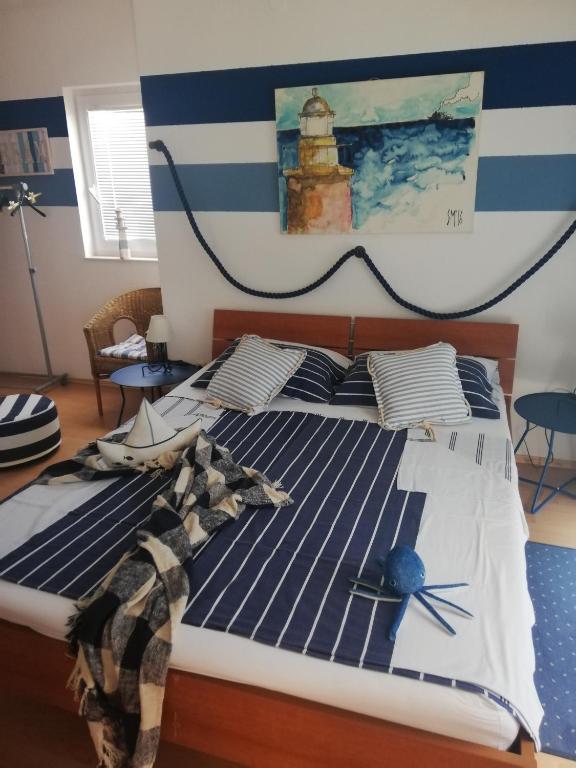 a bedroom with a bed with a lighthouse on the wall at Apartments Eti in Bol