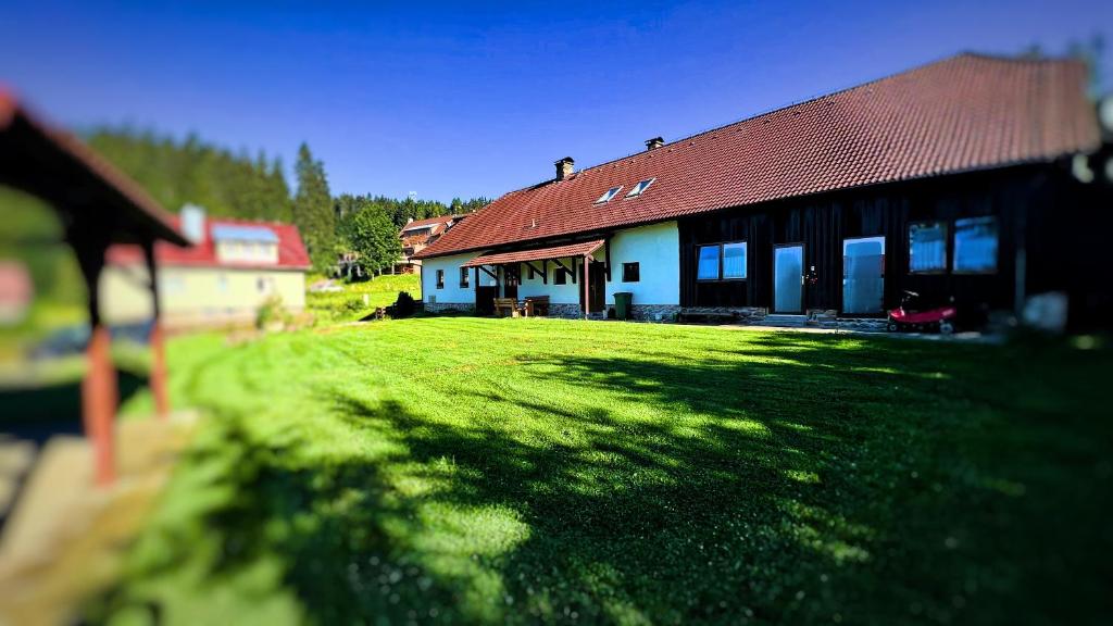 una casa con un patio de césped al lado de un edificio en Kubovka 63, en Kubova Huť