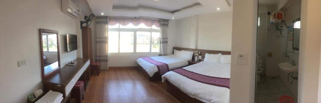 um quarto de hotel com duas camas e uma janela em Hoa Đào Hotel em Sapa