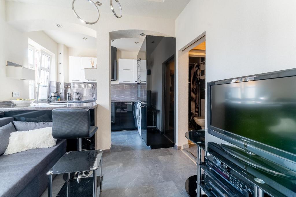 un salon avec une télévision et un canapé dans l'établissement Apartament Ale Antresola! - 4 osobowy przy ratuszu z parkingiem - Space Apart, à Jelenia Góra