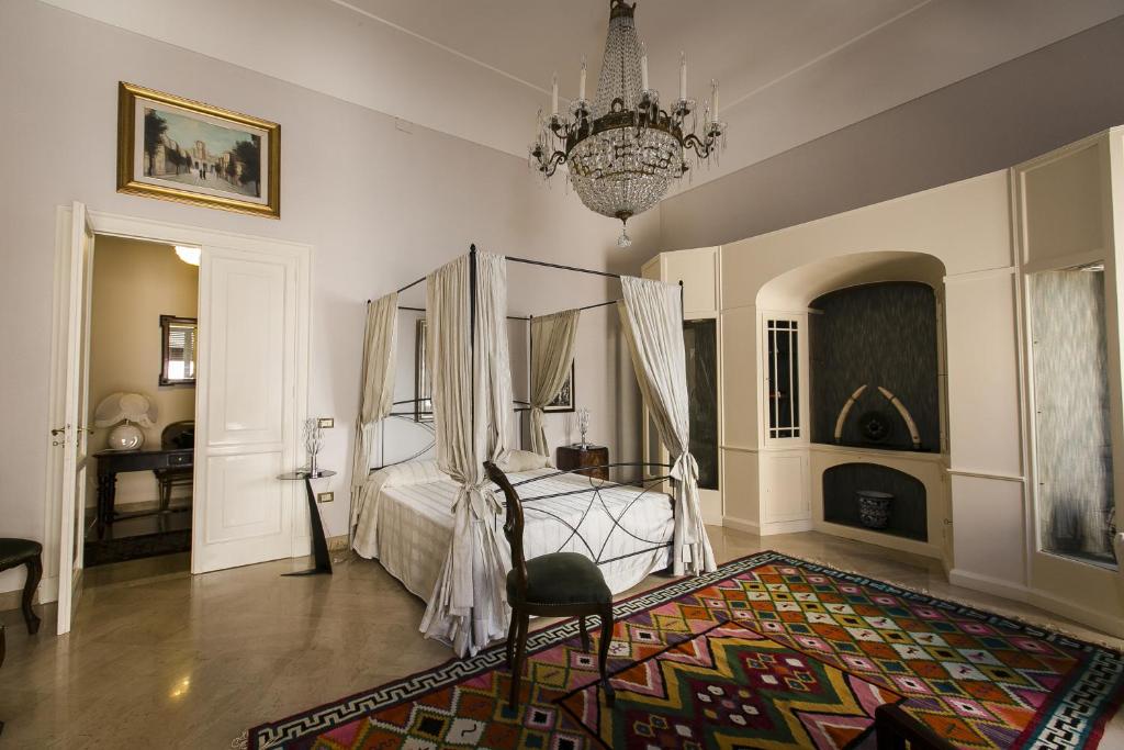 um quarto com uma cama e um lustre em La Casa della Zia Armenia em Marsala