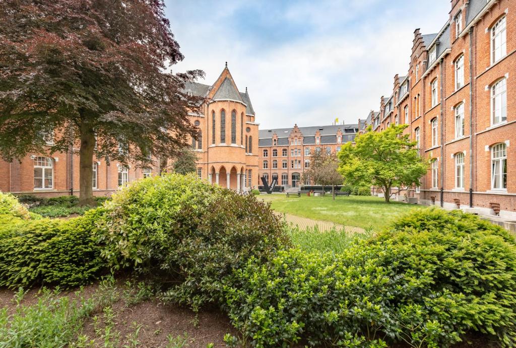 a large brick building with bushes in front of it at Getaway Studios Gent in Ghent