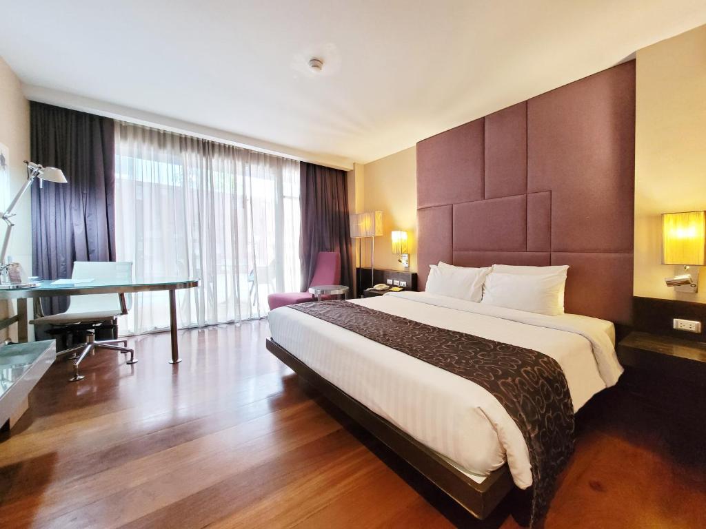 a hotel room with a large bed and a desk at Citichic Sukhumvit 13 by Compass Hospitality in Bangkok