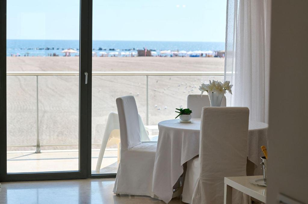 einen Tisch und Stühle mit Blick auf den Strand in der Unterkunft CAELIA Residence ap 2 camere in Mamaia