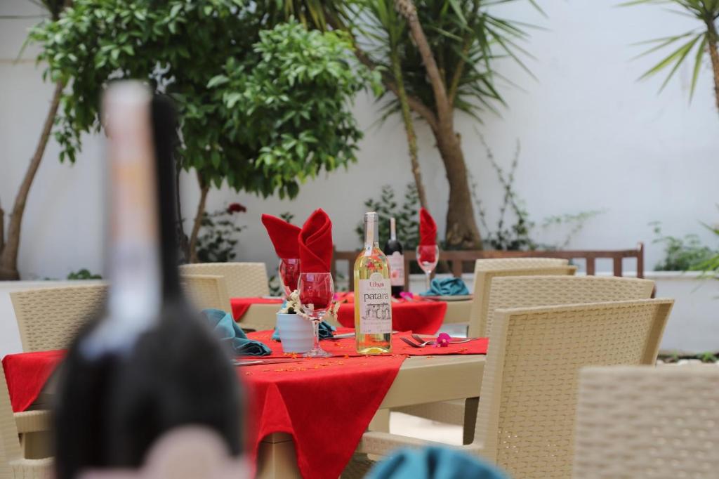 a table with a red table cloth and bottles of wine at Fevkalade & Aparts Otel in Kemer