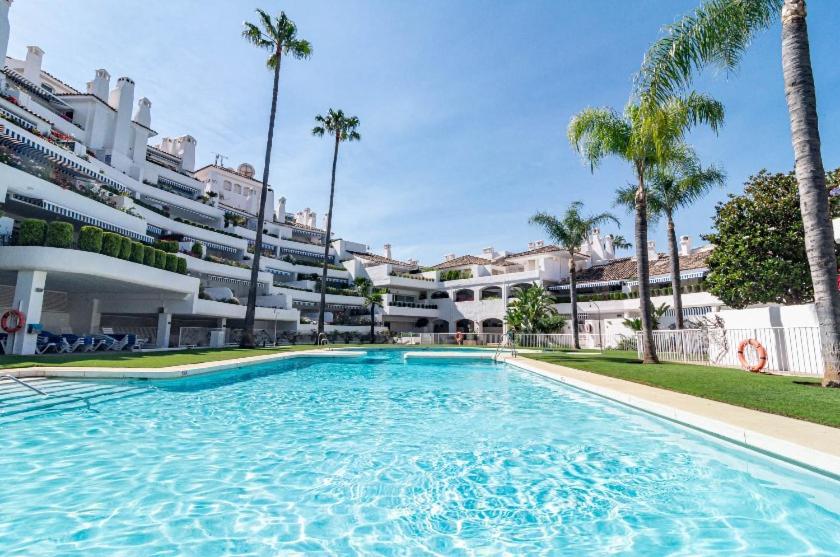 a large swimming pool in front of a building at Casa Birdie By Kura Homes in Marbella